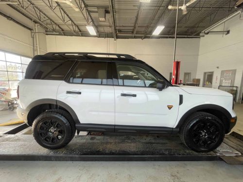 Side profile of a white Ford Bronco with subtle St Barbara company branding on the vehicle doors.