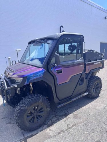 CFMOTO side-by-side ATV with a purple and blue colour-shifting wrap parked outside on a sunny day.
