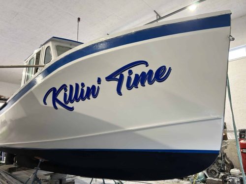 Custom vinyl boat name “Killin Time” applied to white and blue fishing boat hull