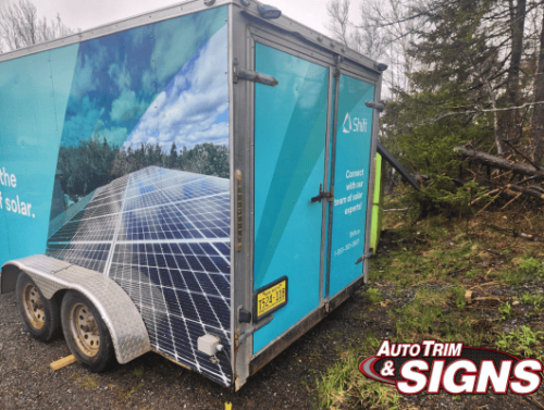 Rear angle view of a trailer wrapped in bright blue, showcasing a large solar panel image and Shift branding, with texts about solar energy and sustainability.