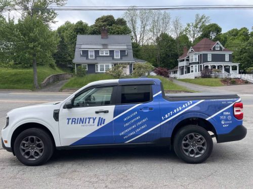 Side profile of a Trinity Energy Group truck featuring custom fleet graphics, company branding, services, and contact information.