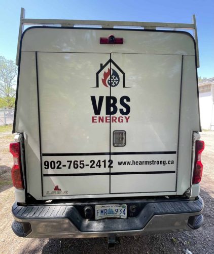 Rear view of a VBS Energy service truck featuring custom company branding, website address, and contact information installed on the utility body doors.
