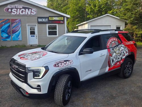 White SUV wrapped with bold red and black Weeks Crushers Jr. A Hockey Club graphics, parked in front of Auto Trim  Signs shop.