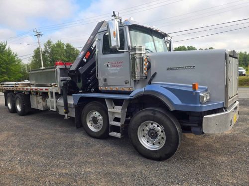 Western Star flatbed truck with crane and Quick Panel Industries branding