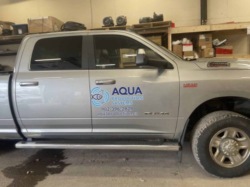 Grey RAM truck with Aqua Production Systems logo, phone number, and website on door