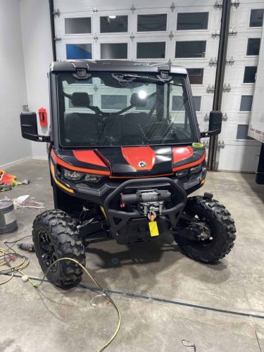 Driver side profile of Can-Am side-by-side with custom Adventure Edition wrap graphics