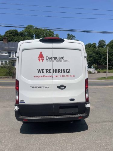 Rear view of Everguard Fire Safety van with company logo, “We’re Hiring” message, website, and phone number.