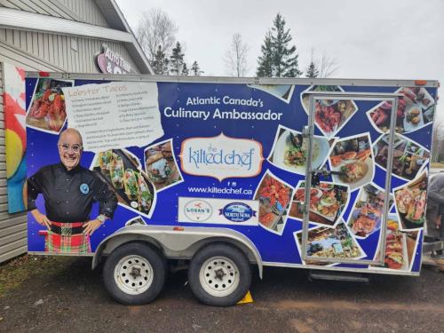 The back of The Kilted Chef’s trailer, showcasing food photography, a recipe for Lobster Tacos, and logos of supporting sponsors.