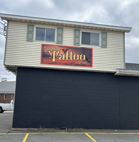 Front view of large Last Stand Tattoo wall sign mounted on exterior building