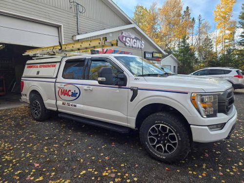 MACair truck parked outside Auto Trim  Signs with fresh vinyl graphics and fall leaves in the background.