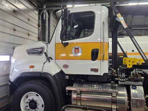 White municipal service truck with yellow reflective stripe and custom door decal featuring the Town of New Glasgow crest, designed and installed by Auto Trim  Signs.