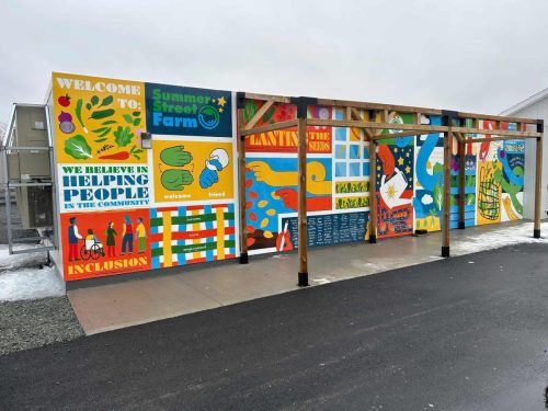 Colorful community mural panels installed at Summer Street Farm, featuring inclusive messaging, bright illustrations, and welcoming signage.