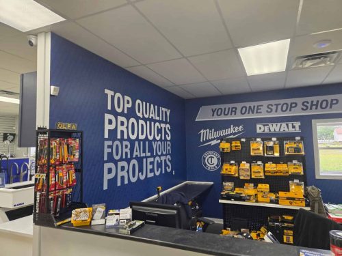 Interior wall graphic at Trinity Tools  Interiors with bold white text reading “Top Quality Products For All Your Projects” on a deep blue background.