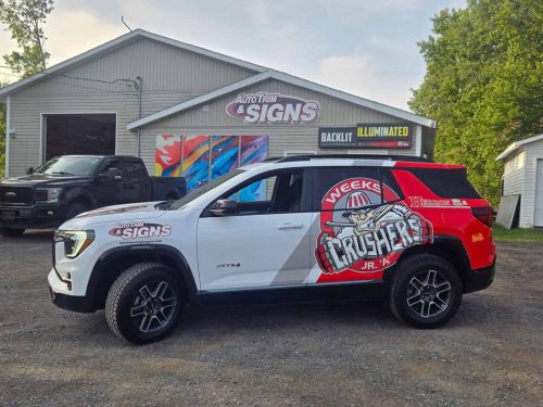 Side view of a white SUV with large red and black Weeks Crushers Jr. A Hockey Club graphics, parked outside Auto Trim  Signs.