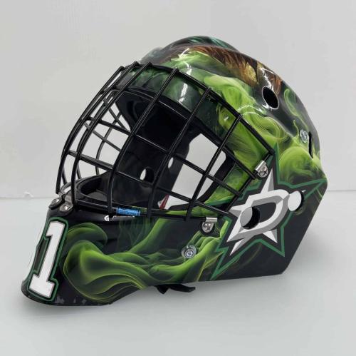  Side view of a custom-wrapped hockey goalie helmet featuring a green smoke effect with a star-shaped logo and the number 3 in bold white.